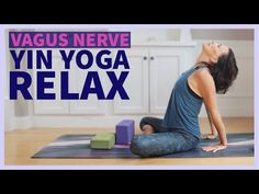 a woman sitting on top of a yoga mat with her head in the air and hands behind her back