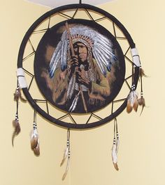 a native american dream catcher with feathers hanging from it's center circle, on a wall