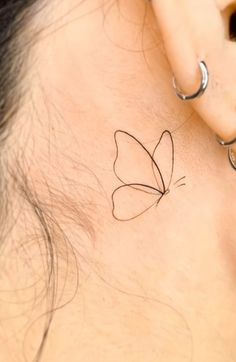 a woman's ear with a butterfly tattoo on it