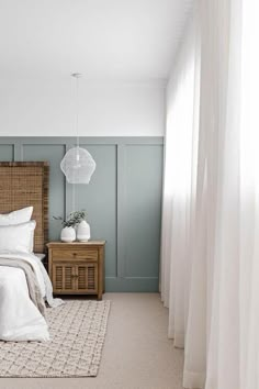 a bedroom with green walls and white curtains