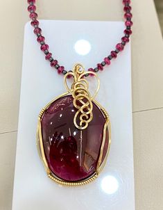 This is Gorgeous beauty Rubilite Tourmaline Neckalce. The Rubilite was born in Brazil and you can see on pics, it has a Deep Red shades. This 90.32carats, biiiiig stone is set in 14k yellow gold wire along with Rubilite Tourmaline beads Chain with silver clip. This plain Oval cabochon Cut Stone is perfect for a any high end jewelry. This shade is considered Rubilite Tourmaline and big size ones are hard to get and ones that available are not cheap. Grab this one. Pendant Length- 2 inches Necklace length (pendant+beads chain) - 11.50inches Cheap Red Jewelry With Silver Beads, Cheap Red Oval Bead Jewelry, Dark Red Color, Red Shades, High End Jewelry, Beads Chain, Tourmaline Necklace, Tourmaline Beads, Gold Wire