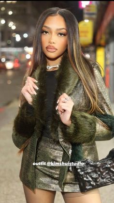 a woman with long hair wearing a fur coat and holding a handbag on the street