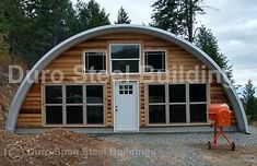 a small wooden cabin with windows and a grill