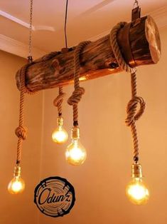 several light bulbs hanging from a wooden beam with rope wrapped around them and plugged into the ceiling