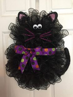 a black cat wreath hanging on the front door