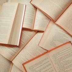 several open books laying on top of each other in the middle of a pile together