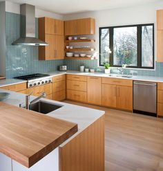 a modern kitchen with wooden cabinets and stainless steel appliance in the center island