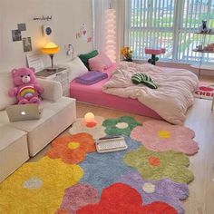 a bedroom decorated in pastel colors with teddy bears on the floor and rugs