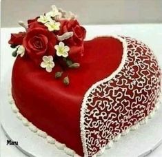 a heart shaped cake with flowers on top