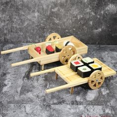 a wooden cart with sushi on it sitting on a stone floor next to a wall