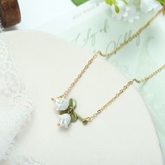 Lily of the Valley Necklace is designed according to little bell-shaped flowers. This exquisite necklace is a piece of fine jewelry made with freshwater pearls and very popular on Selenichast online shop and on Instagram as well. Elegant Flower Necklace With Pearl Chain As Gift, Elegant Pearl Chain Flower Necklace As Gift, Gold Pearl Flower Necklace For Gift, Flower-shaped Pearl Necklace Chain As A Gift, Flower Shaped Pearl Charm Necklace As Gift, Flower Shaped Pearl Charm Necklace For Gift, Flower Shaped Pearl Charm Necklace Gift, Delicate Pearl Flower Necklace Gift, Delicate Pearl Flower Necklace For Gift