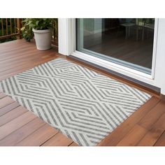 a door mat that is on top of a wooden floor next to a glass door