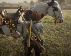 two people standing next to a white horse in a field