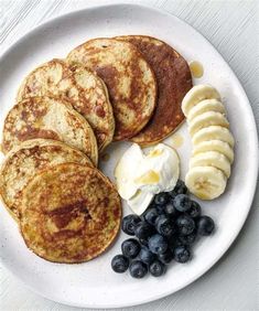 pancakes, blueberries and butter on a white plate