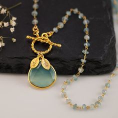 This listing is for a beautiful bezel set Aqua Blue Chalcedony stone in 18k gold vermeil with an 18k gold vermeil toggle clasp lariat necklace. The chain is hand wire wrapped natural Aquamarine. The leaf charms are 16k gold plated base metal. ✦Please leave me a comment during checkout with Cheap Handmade Gold Plated Jewelry, Cheap Artisan Gold Necklaces, Luxury Elegant Chalcedony Necklace, Luxury Chalcedony Necklace With Natural Stones, Luxury Bohemian Chalcedony Necklaces, Luxury Bohemian Chalcedony Necklace, Jewelry Aquamarine, Surf Necklace, March Birthstone Necklace