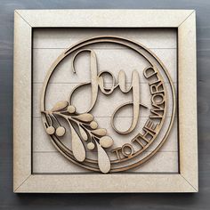 a wooden plaque with the words joy and an olive branch on it in a frame