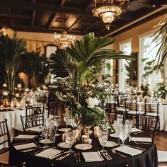 a table set up with place settings and greenery for an elegant wedding or reception