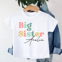 Big Sister T-Shirt, Big Sister Boho T-Shirt, Promoted To Big Sister, Personalised T-shirt, Pregnancy announcement, Going To Be A Big Sister Personalised Big Sister t-shirt T-shirt is 100% Australian cotton.  We design & print our products with care & love! We use the best quality vinyls, inks & transfers on all products. * * * * * * * * * * * * * * * * * * * * * * * * * * * * * CARE INSTRUCTIONS: Wash inside out on gentle wash, Do not tumble dry. * * * * * * * * * * * * * * * * * * * * * * * * * * * * * SHIPPING: We want to get your product to you as quickly as possible, your purchase will be shipped through Australia post, Express post is available for selection. * * * * * * * * * * * * * * * * * * * * * * * * * * * * * GUARANTEE: We stand behind our products with a 100% guarantee; if you Cute Multicolor T-shirt With Name Print, White Custom Print Family Matching T-shirt, White Custom Print Family T-shirt, White Short Sleeve T-shirt For Family Matching, White Graphic Tee With Name Print, Multicolor Crew Neck T-shirt With Name Print, Basic White Shirt With Funny Text, Basic White Shirt With Name Print, White Crew Neck T-shirt With Name Print