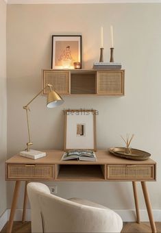 a wooden desk topped with a lamp next to a white chair