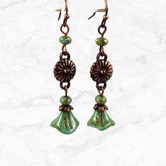 Boho long green earrings made with Czech glass flower beads. Beautiful handmade Czech glass beads with Picasso finish gives them depth and a feeling of being in nature. These long green dangle earrings are perfect for the nature lover, they evoke the forest. Mossy sage green is trending now!  Available in antique copper, silver or brass. Select metal finish in dropdown menu. Hypoallergenic ear wires (nickel and lead free). Choose ear wire style at checkout.  Free gift packaging included. Earring Czech Glass Dangle Earrings With Bead Caps, Green Flower-shaped Jewelry With Dangling Beads, Green Glass Flower-shaped Jewelry, Green Flower-shaped Glass Jewelry, Green Dangling Bead Flower Earrings, Green Czech Glass Flower Earrings, Green Czech Glass Drop Earrings, Green Dangle Flower Earrings With Beads, Green Adjustable Dangle Flower Earrings