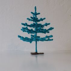 a small blue tree sitting on top of a white table