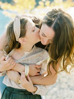 two women are kissing each other while one woman is holding her arm around the other