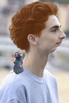 a man with red hair and a mouse on his ear