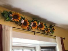 the sunflowers are hanging on the wall above the window