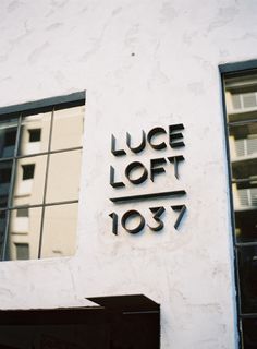 the side of a white building with black lettering on it