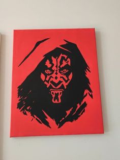 a red and black painting on a white wall