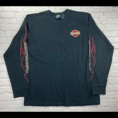 a black long sleeved shirt with red writing on the sleeves and an image of a motorcycle