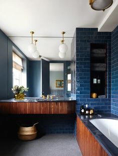 a large bathroom with blue brick walls and wood accents, along with a white bathtub