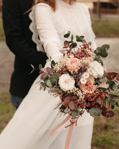 the bride and groom are holding their wedding bouquet