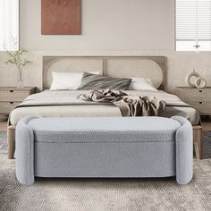 a bedroom with a bed, dresser and footstool on the carpeted floor