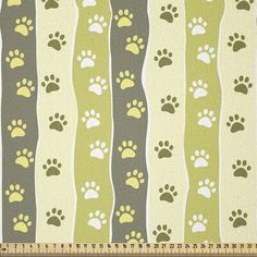 a green and white striped fabric with dog paw prints on the front, along with grey stripes