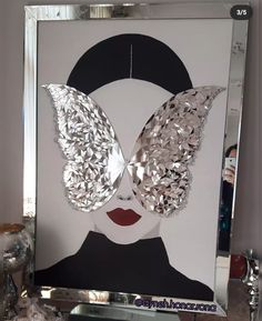 a mirror with a woman's face and butterfly wings on it