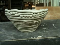 a large white bowl sitting on top of a black table in front of a building