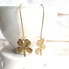 These are super cute lucky shamrock earrings. These fun good luck four leaf clover brass charms hang from simple ear wires Each earring measures approx 2 1/2 inches from the top of the ear wire to the bottom of the charms. Clover charms measures just under 1 inch by 1 inch. The three leaves of a shamrock are also said to stand for faith, hope and love. A fourth leaf is uncommon and considered to be a symbol of good luck. Matching necklace available here- https://www.etsy.com/listing/947083441/lu Brass Charm Earrings As Gift, Brass Earrings With Charms For Gifts, Brass Earrings With Charms As Gift, Gold Jewelry For St. Patrick's Day Gift, Brass Earrings With Dangling Charms As Gift, Irish Earrings, Shamrock Earrings, Celtic Earrings, Lucky Shamrock