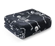 a black blanket with skulls and bones on it