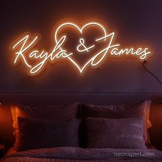 a neon sign that says kayla and james on it's wall above a bed