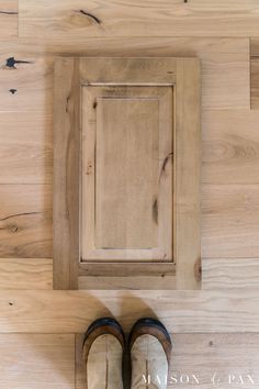 a pair of shoes sitting on top of a wooden floor next to a cabinet door