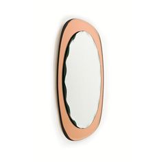 an oval shaped mirror on the wall with a pink frame and black trim around it