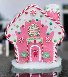 a pink gingerbread house decorated with candy canes