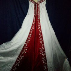 a white and red wedding dress on display