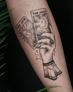 a tattoo on the arm of a woman holding a book with an image of a baby in it