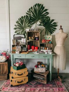 a green table topped with luggage next to a palm leaf wall mounted on the wall