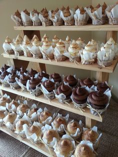 a wooden shelf filled with lots of different types of cupcakes