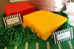 a table topped with lots of paper plates and napkins on top of green grass