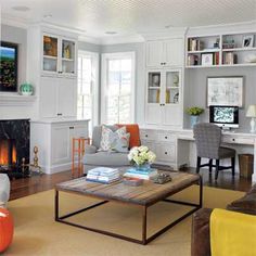 a living room filled with furniture and a fire place under a mirror on the wall