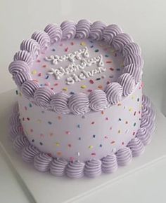 a birthday cake with sprinkles on it sitting on a white counter top